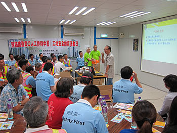 An Occupational Hygienist explaining heat stroke prevention to workers in a construction site promotional visit