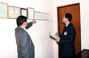 A labour inspector enforcing the Employees' Compensation Ordinance to ensure employers possess valid insurance cover for their employees.