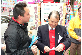「青年自僱支援計劃」學員於跳蚤市場活動當日,向經濟發展及勞工局常任秘書長(勞工)張建宗(右)介紹其自僱業務。